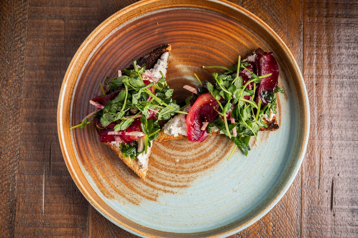 a bowl of food on a plate on a wooden table