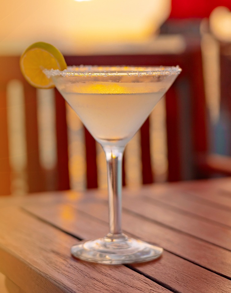 Margarita with lime on a wooden table during golden hour