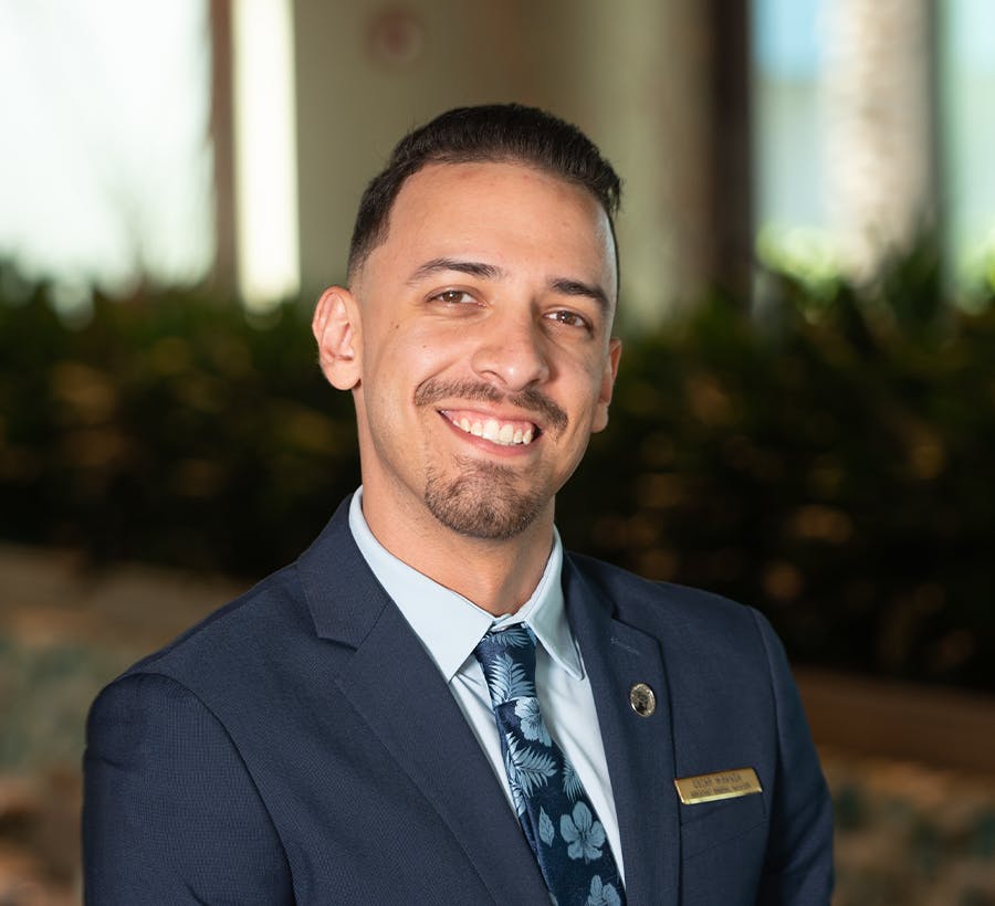 a man wearing a suit and tie smiling at the camera