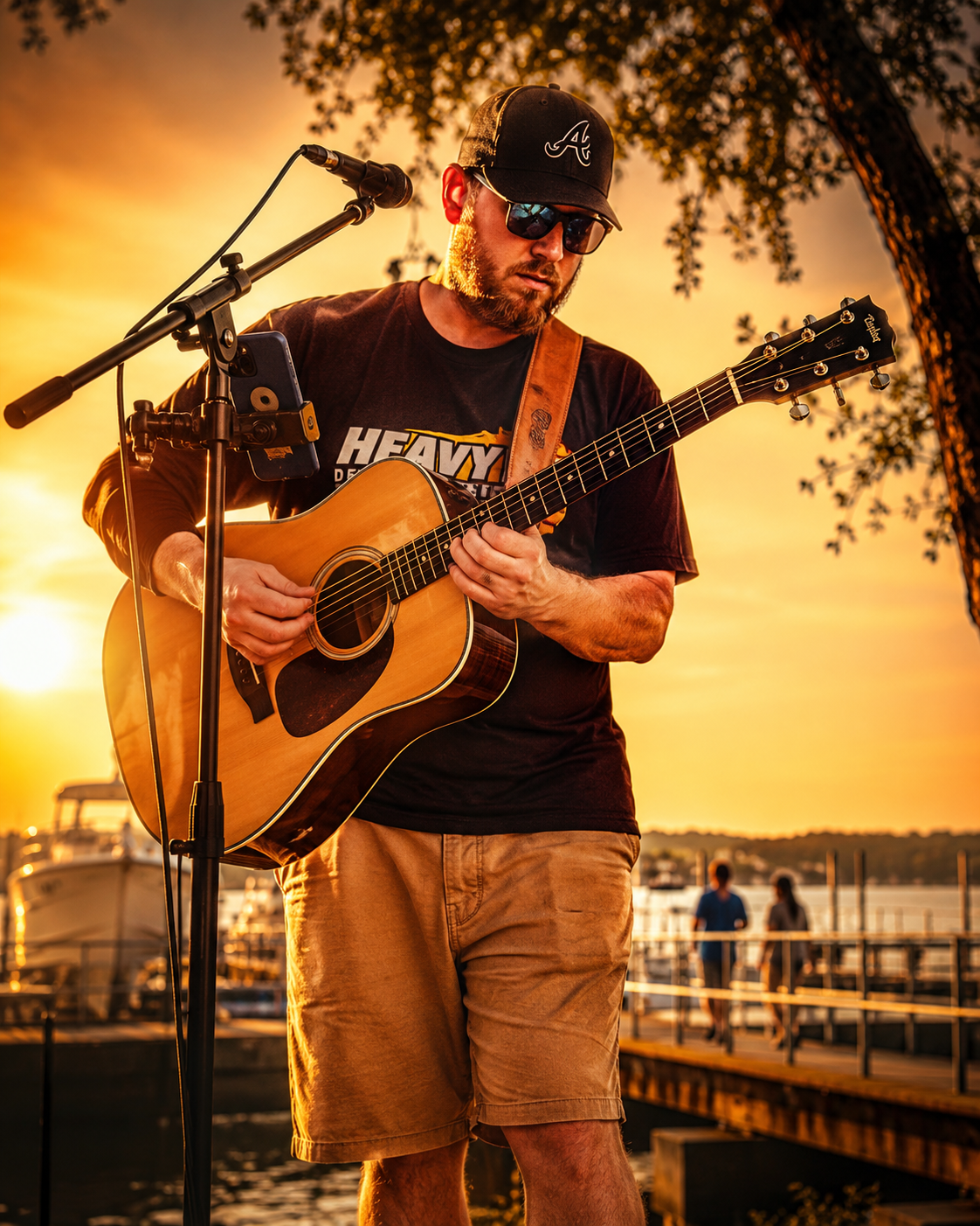 a man playing guitar and standing on a dock
