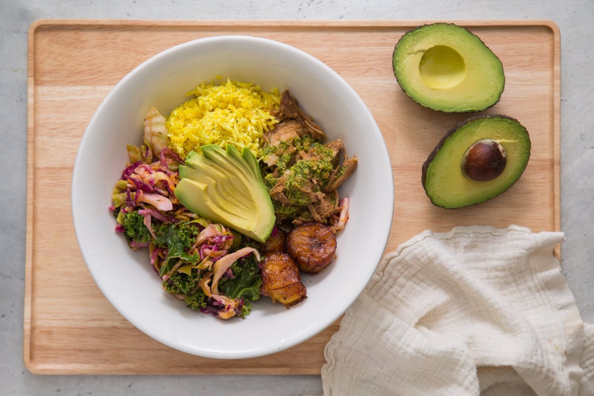 a bowl of food sitting on top of a wooden table