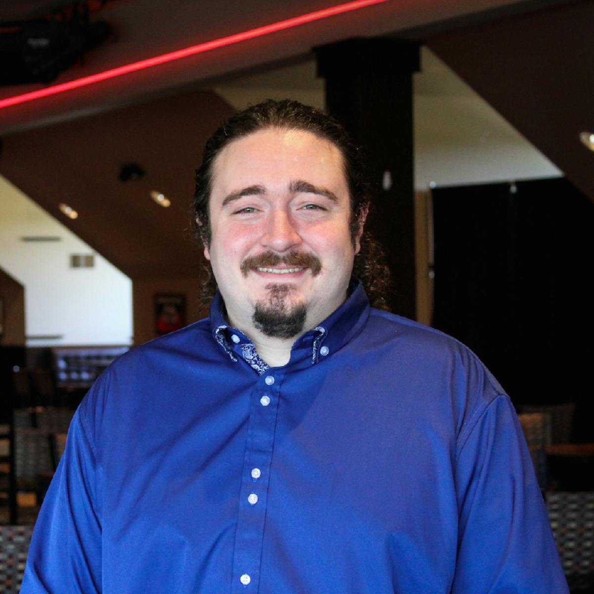 a man in a blue shirt and smiling at the camera