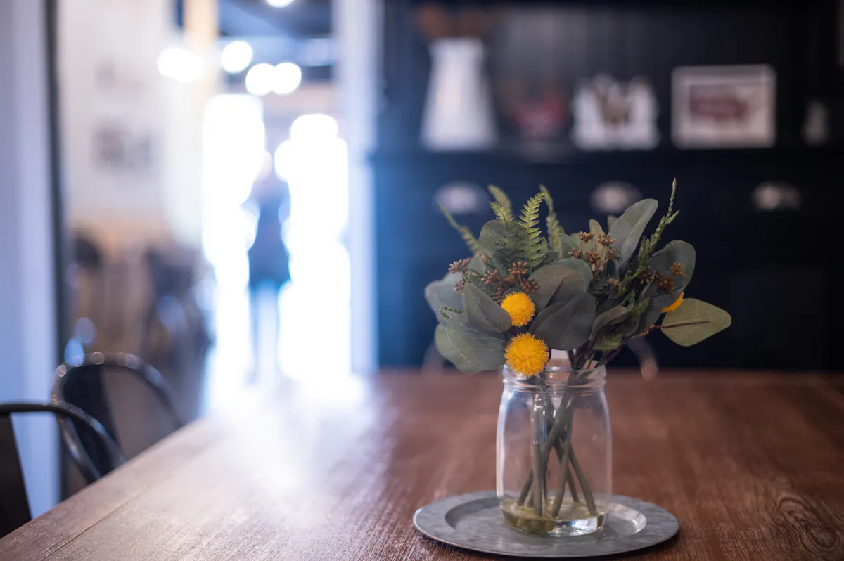 a close up of a glass vase filled with flowers sitting on a table