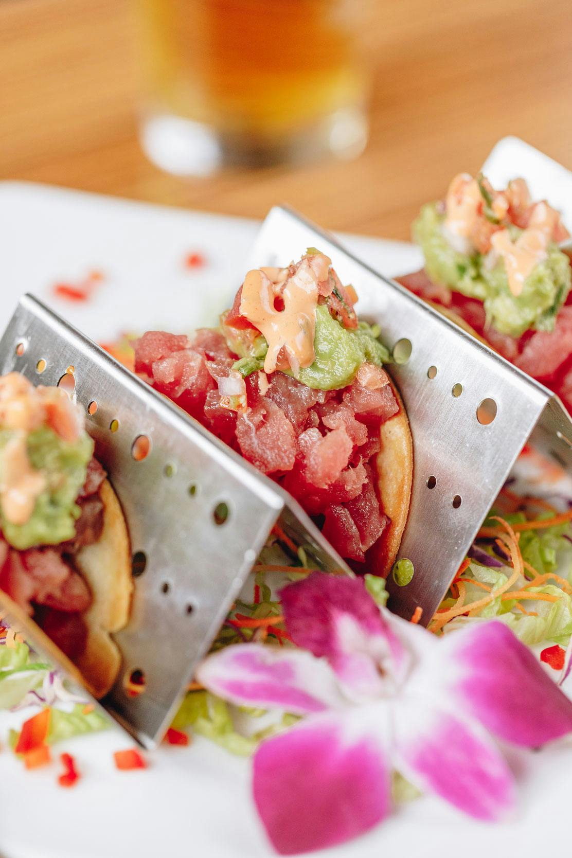 three small triangular containers with meat and vegetables in them