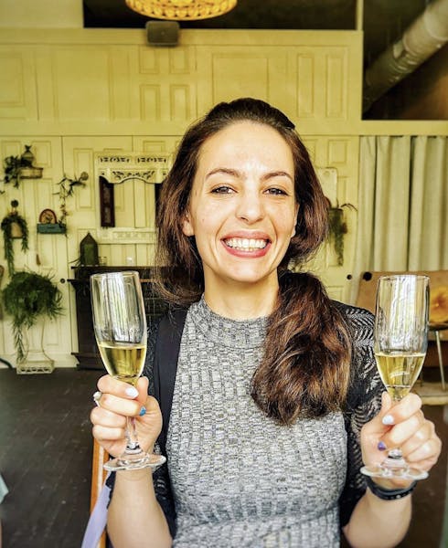 a person holding two champagne glasses