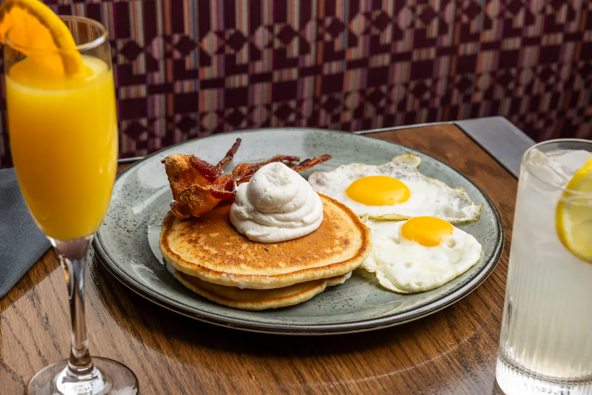 a plate of food and a glass of orange juice