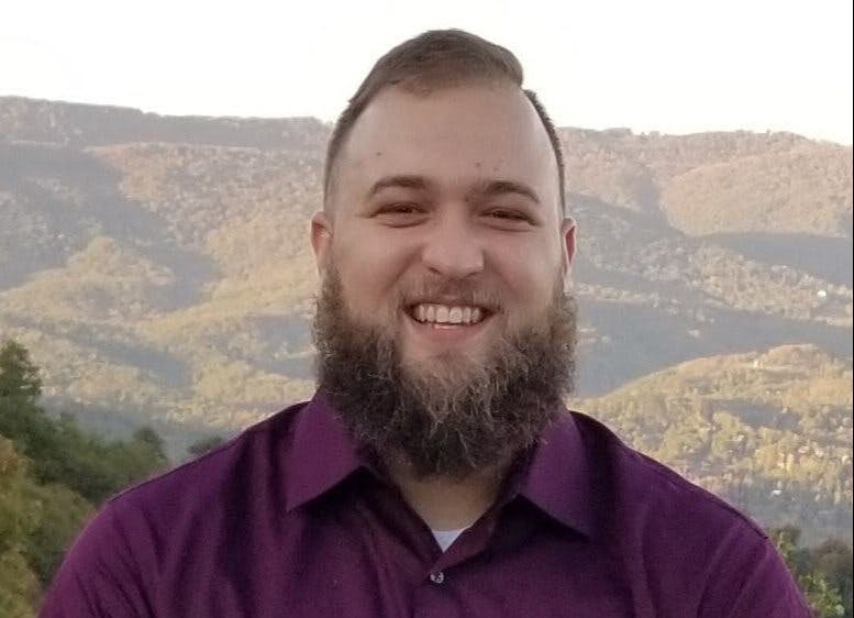 a man standing in front of a mountain