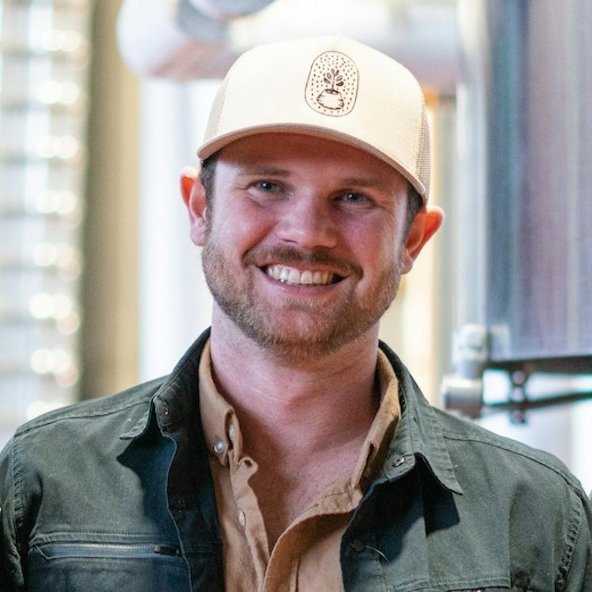 a man wearing a hat and smiling at the camera
