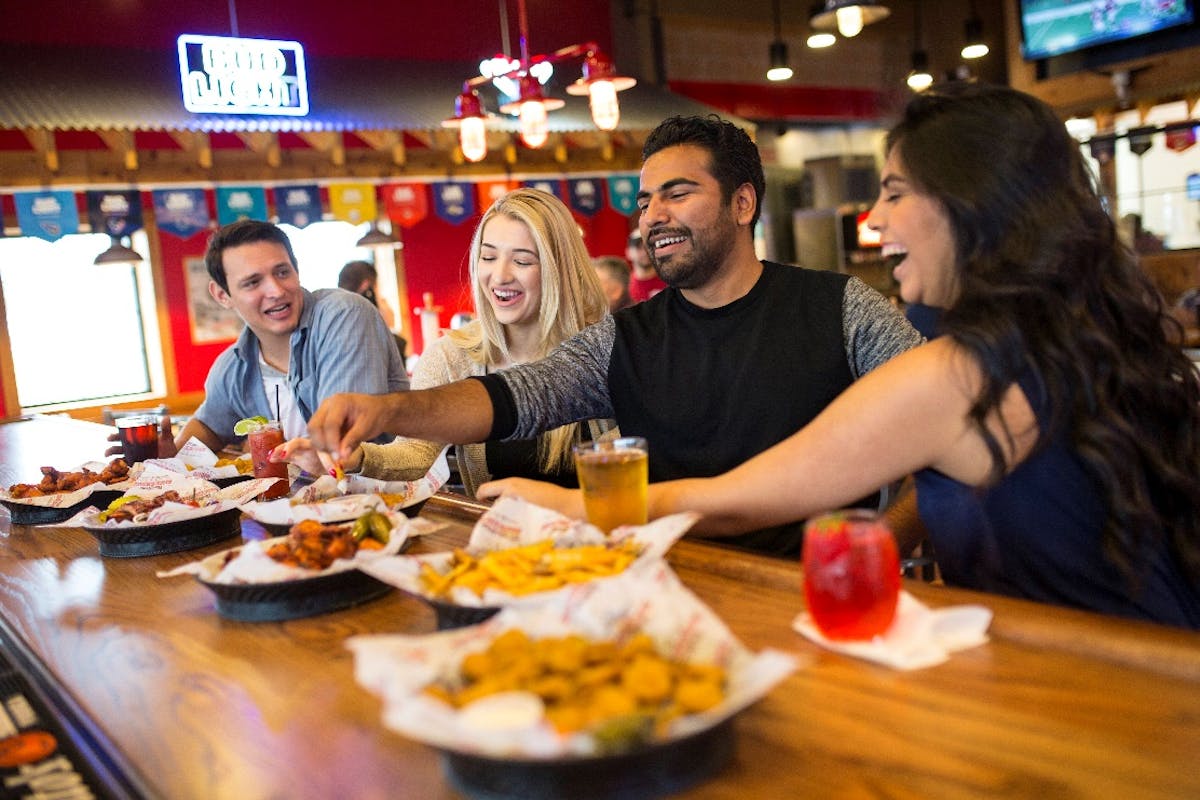 a group of people sitting at a table eating food