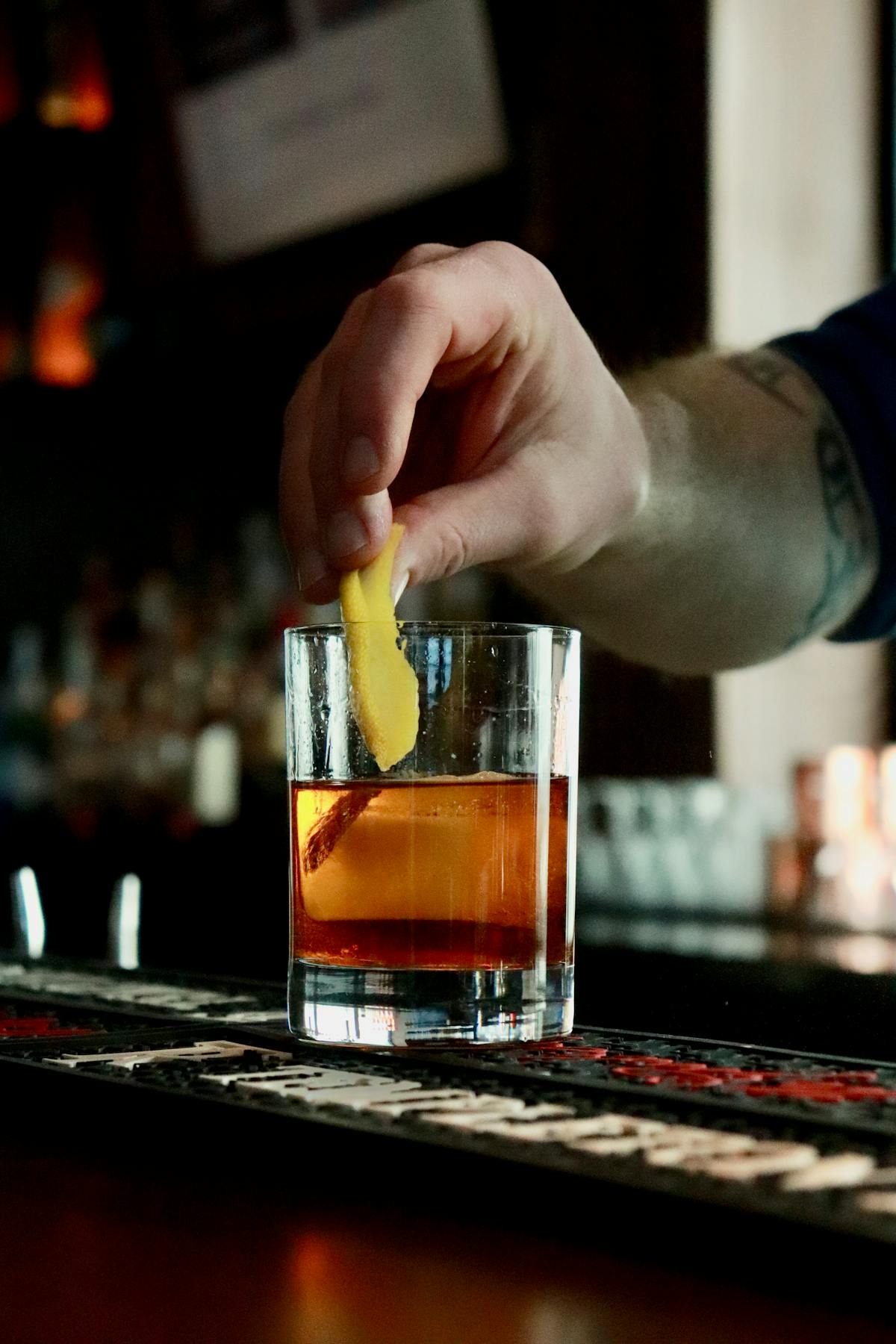 a hand holding a glass of beer on a table