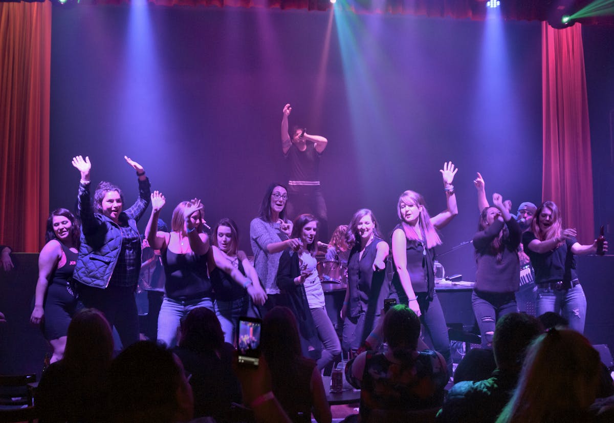 a group of people on a stage in front of a crowd