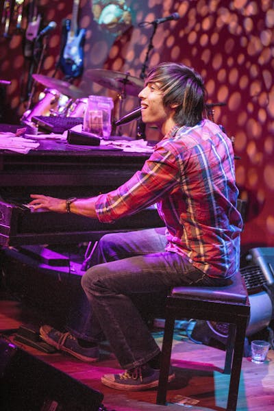 a person sitting on a stage playing instruments