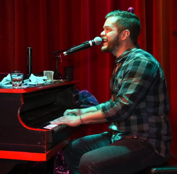 a man sitting on a stage with a piano