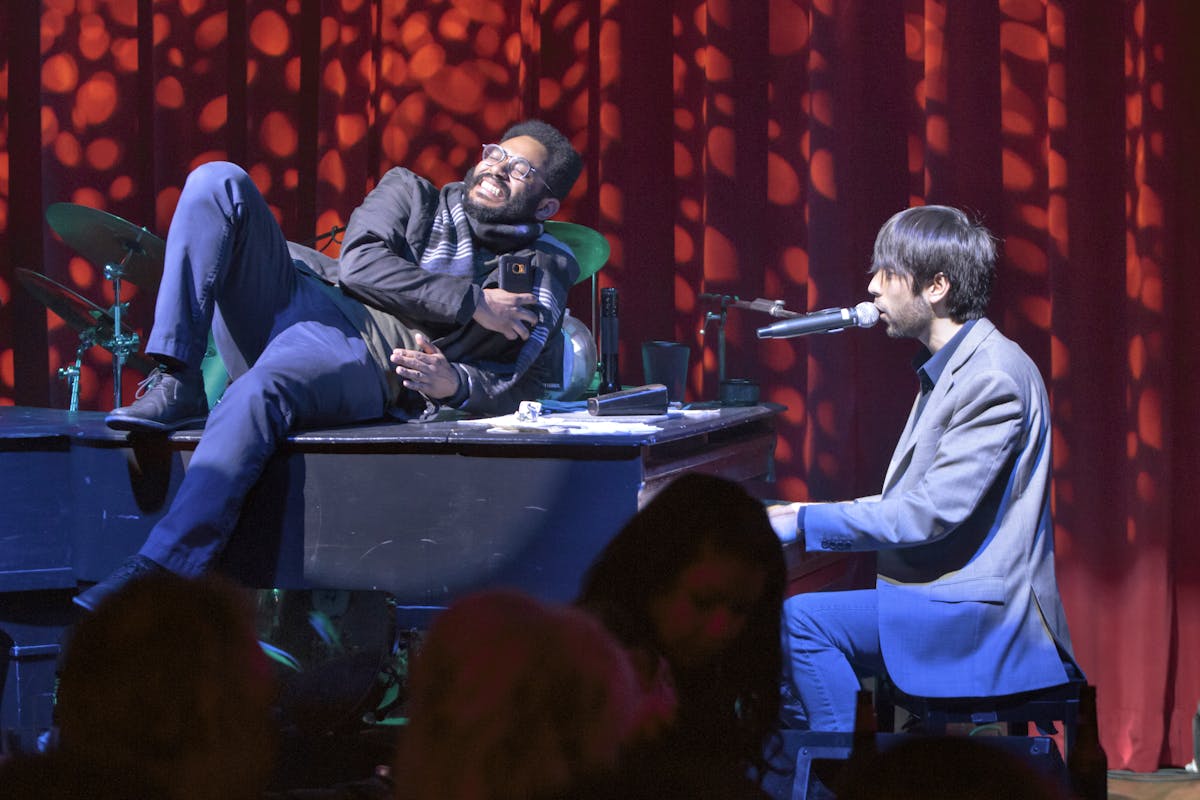 a man sitting on a stage in front of a laptop