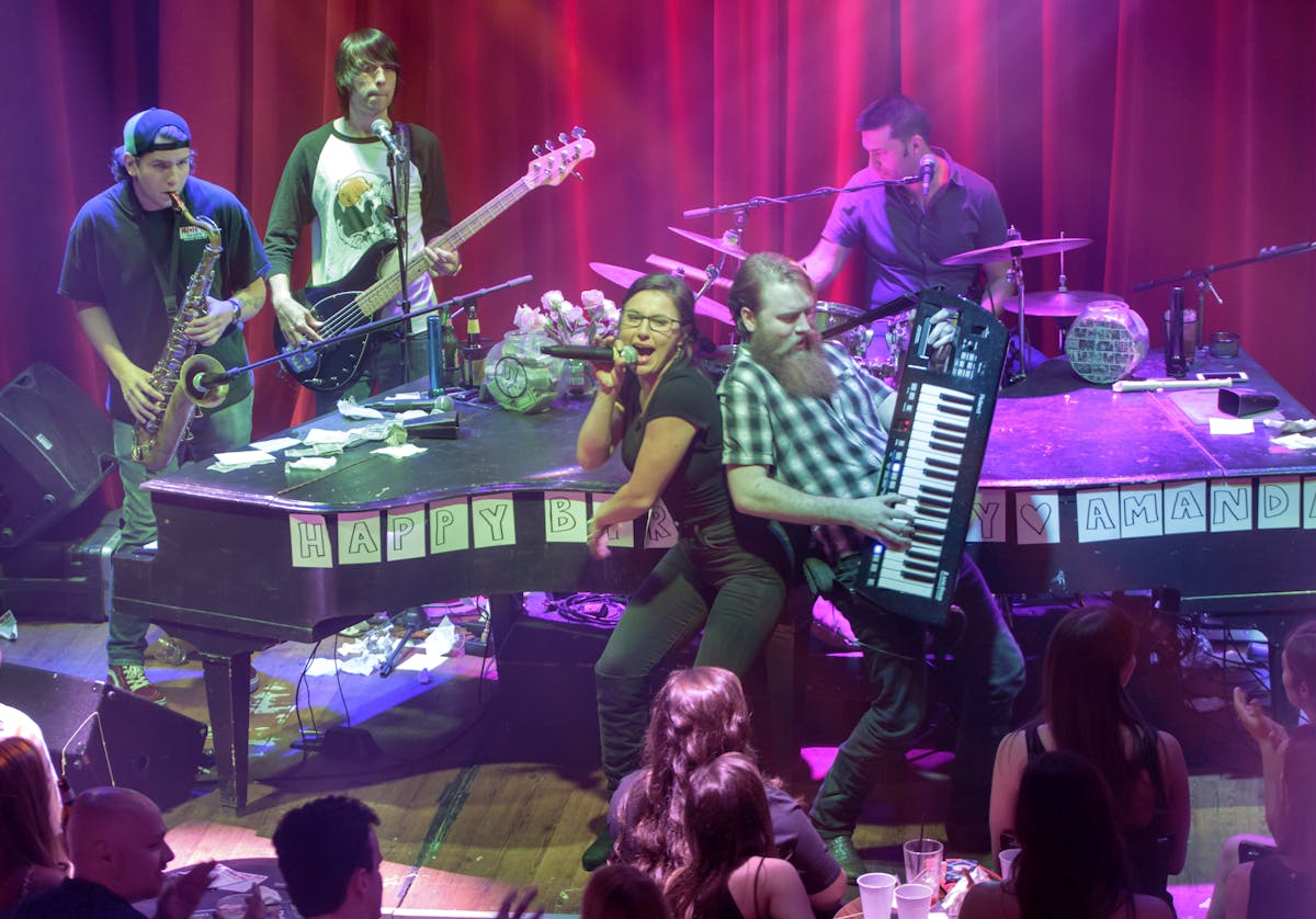 a group of people playing instruments on a stage in front of a crowd