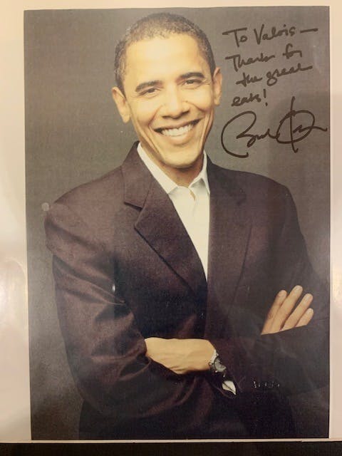 Barack Obama wearing a suit and tie posing for a photo