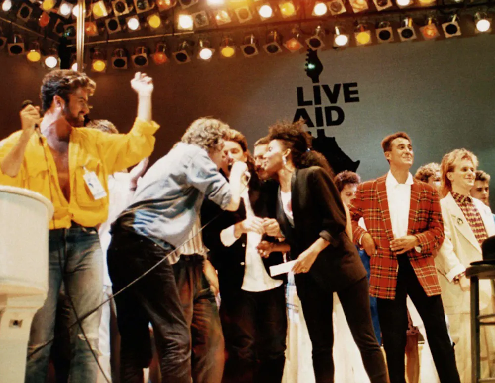 a group of people watching a band on stage in front of a crowd