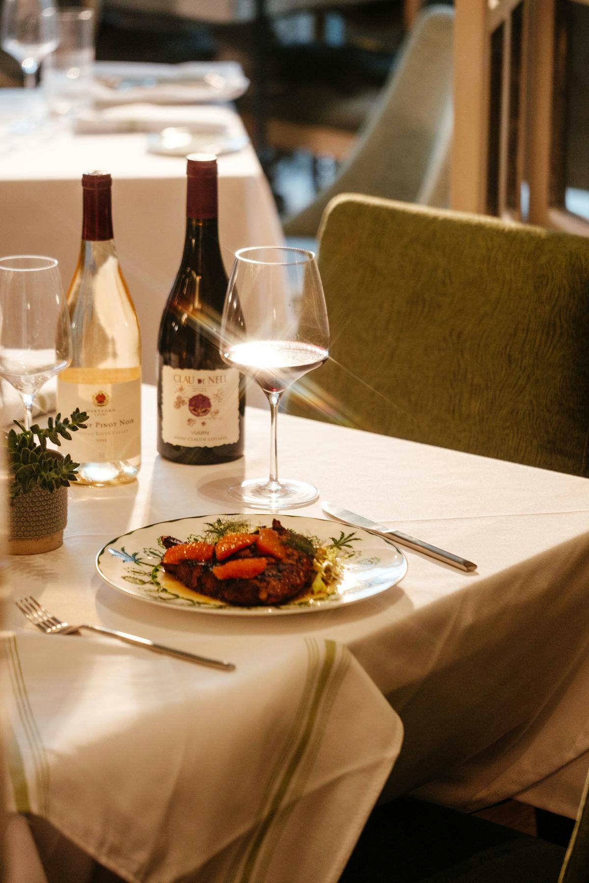 a plate of food and glasses of wine sitting on top of a table