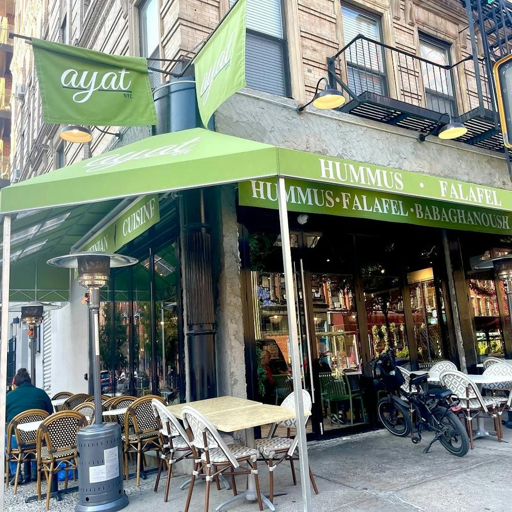 a group of people sitting at a table in front of a store