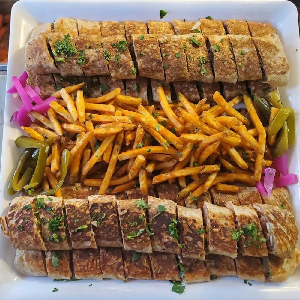 a cut in half sandwich sitting on top of a pile of fries