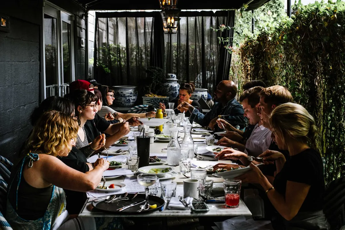 a group of people sitting at a table eating food