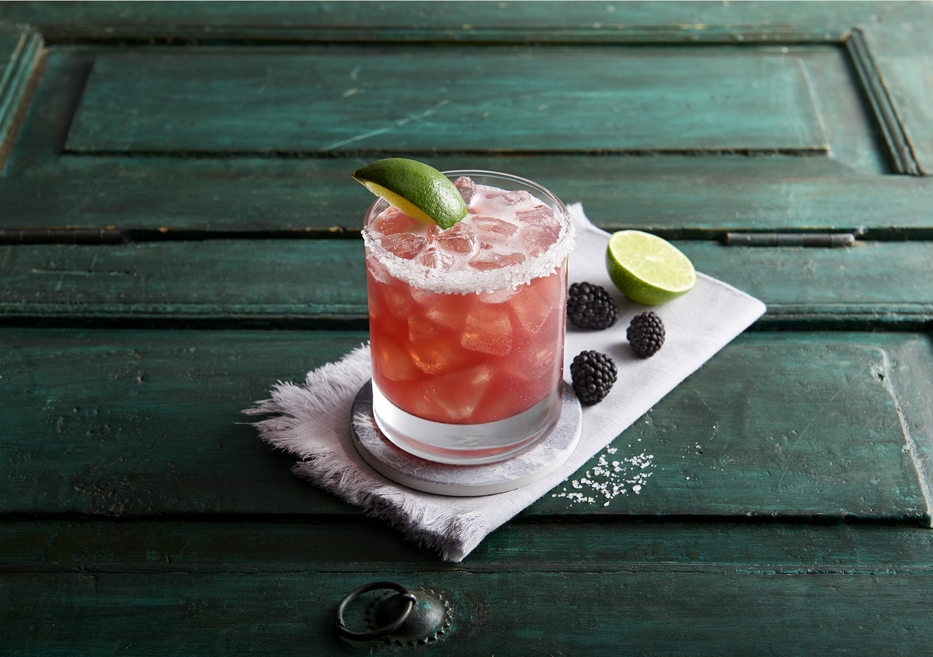 a green bench sitting next to a cup of coffee
