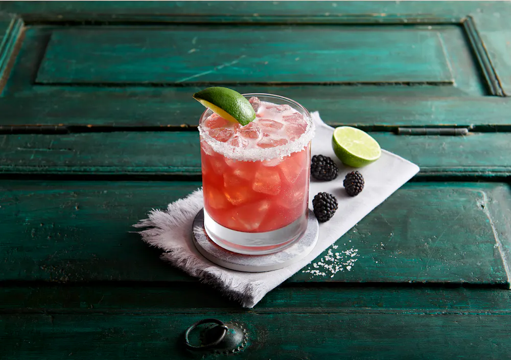 a green bench sitting next to a cup of coffee