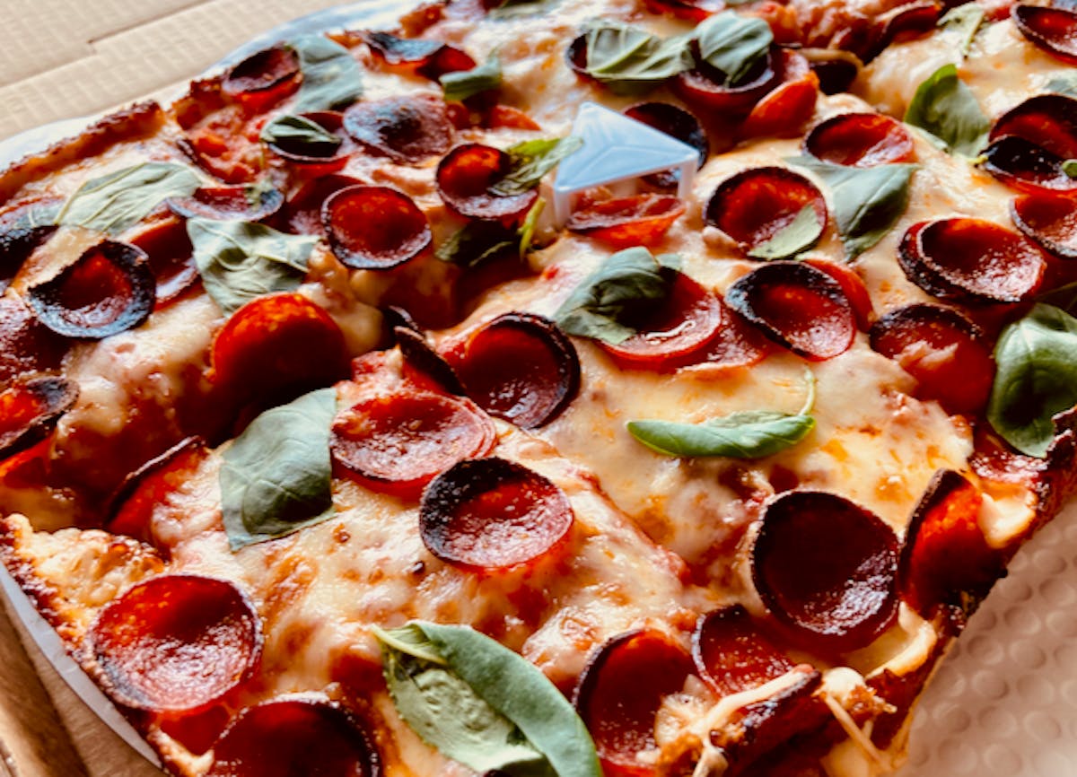 a large pepperoni pizza on a tray