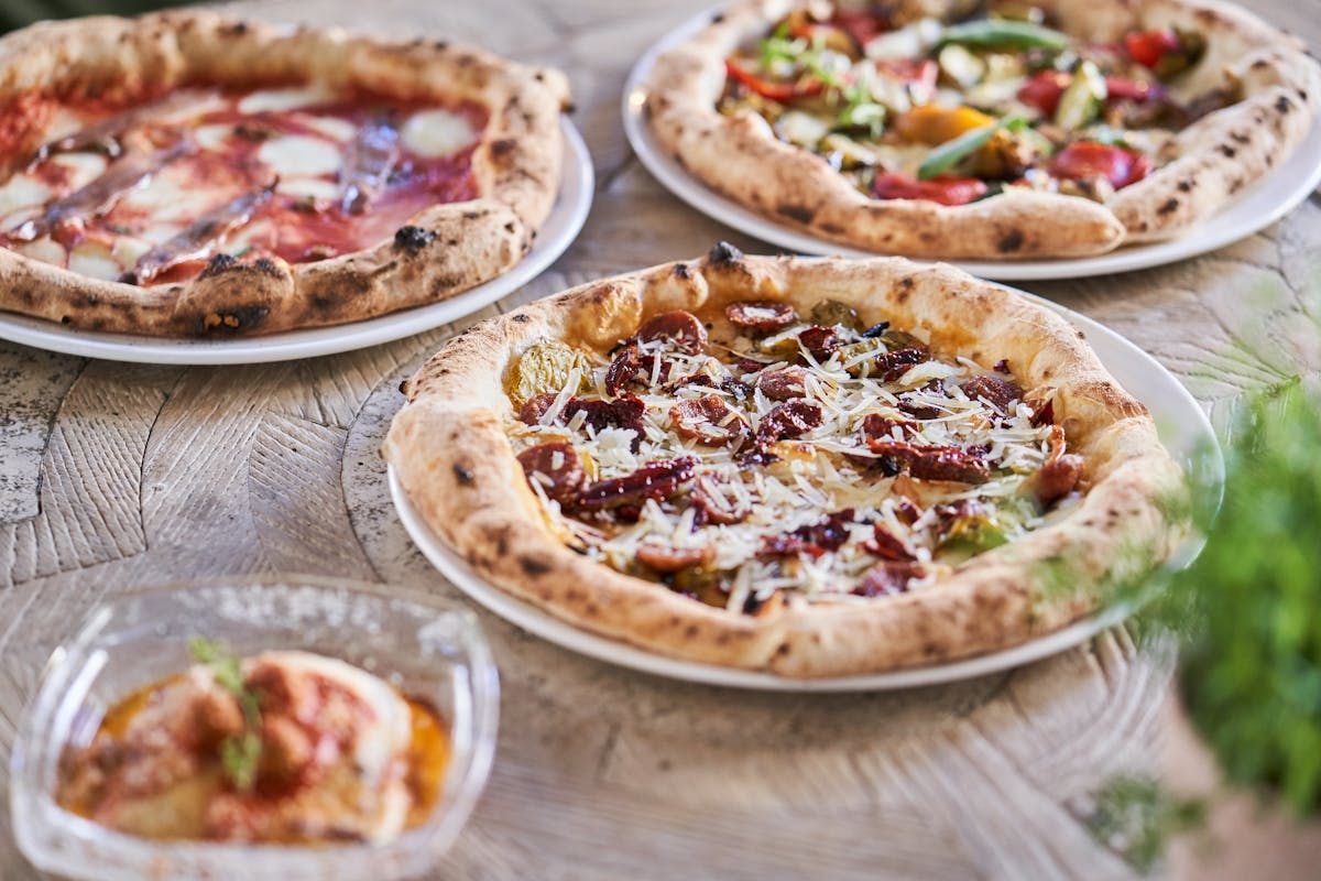 a pizza sitting on top of a wooden table