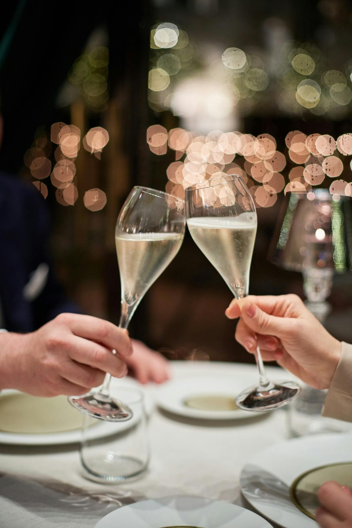 a person sitting at a table with wine glasses