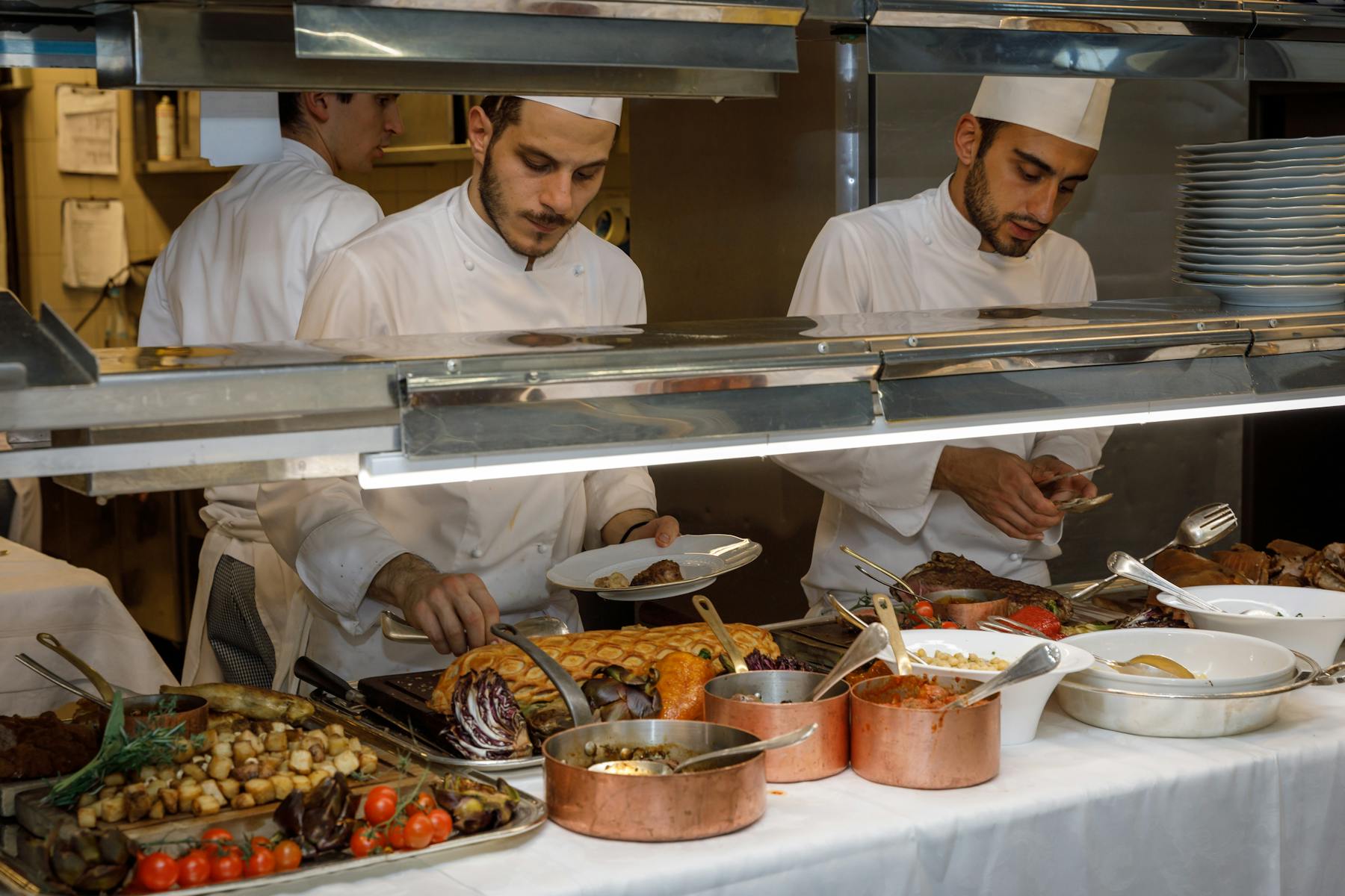 a group of chefts preparing food in a kitchen