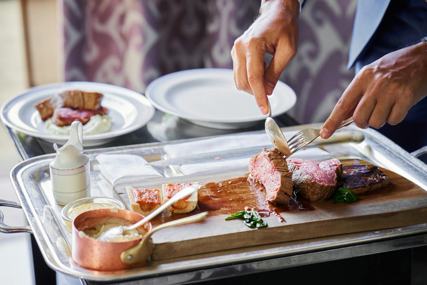 a person holding a plate of food on a table