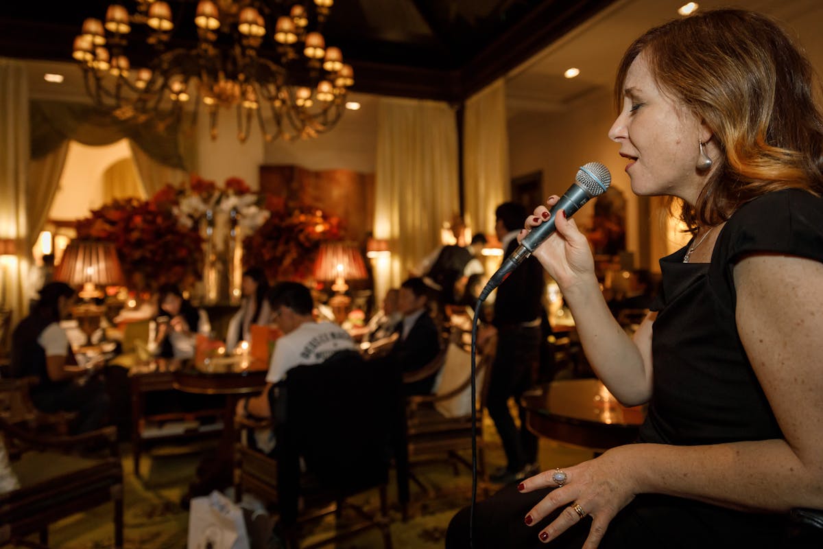 a person sitting at a table with wine glasses