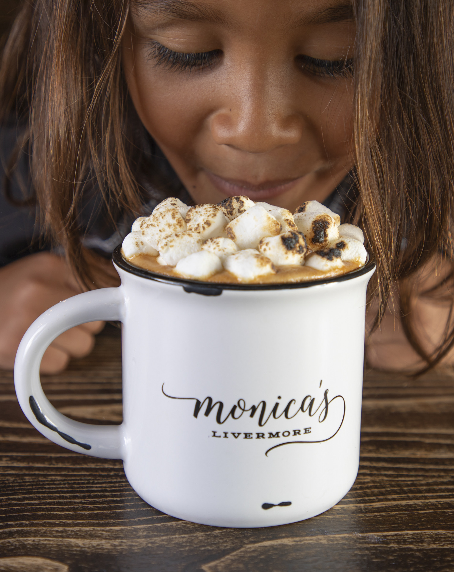 a woman sitting at a table with a cup of coffee