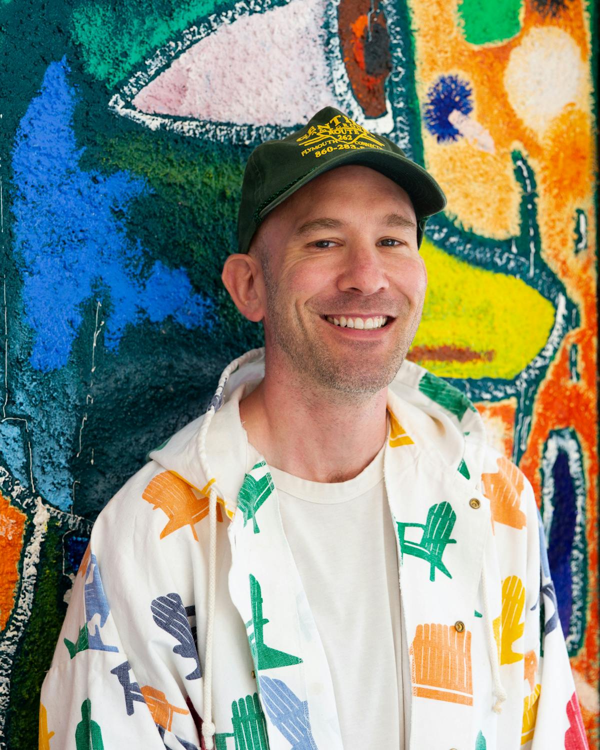 a man wearing a hat and smiling at the camera