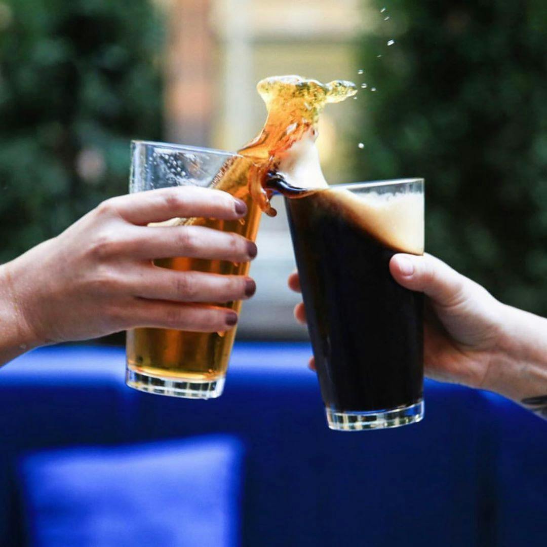 a hand holding a glass of beer