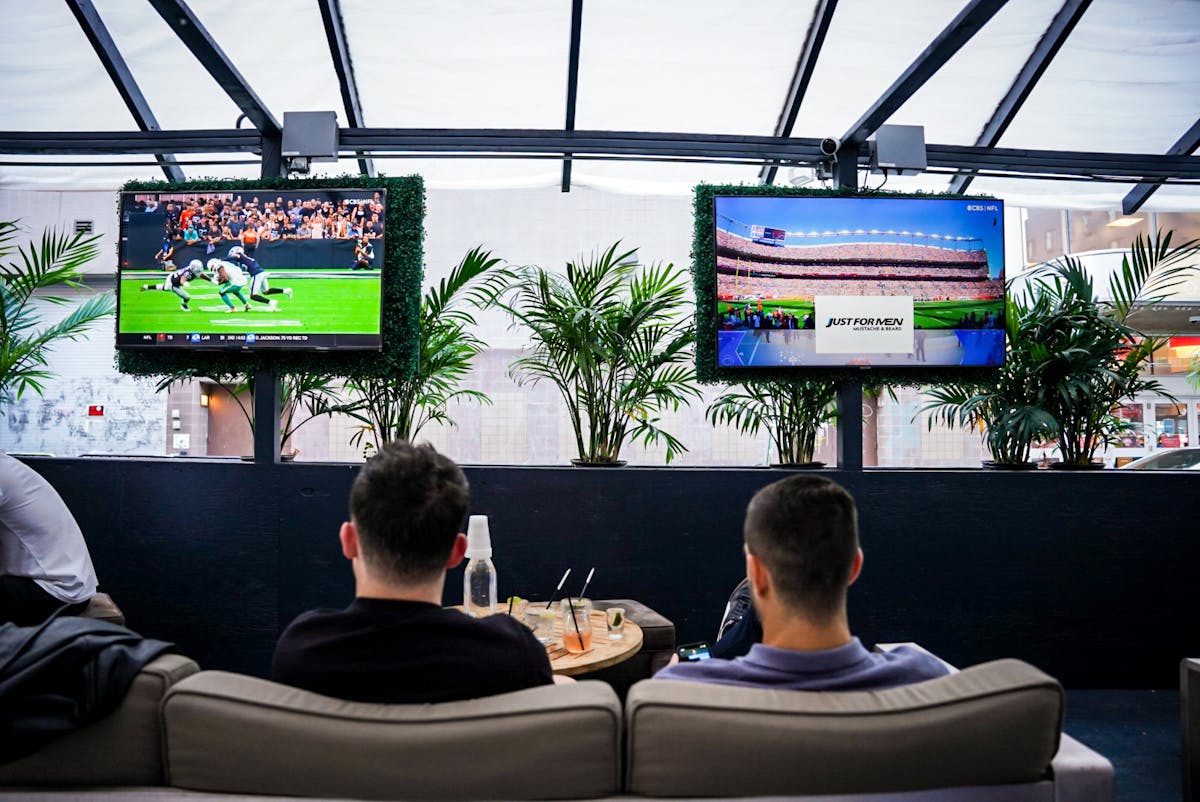 a group of people sitting in front of a television playing a video game