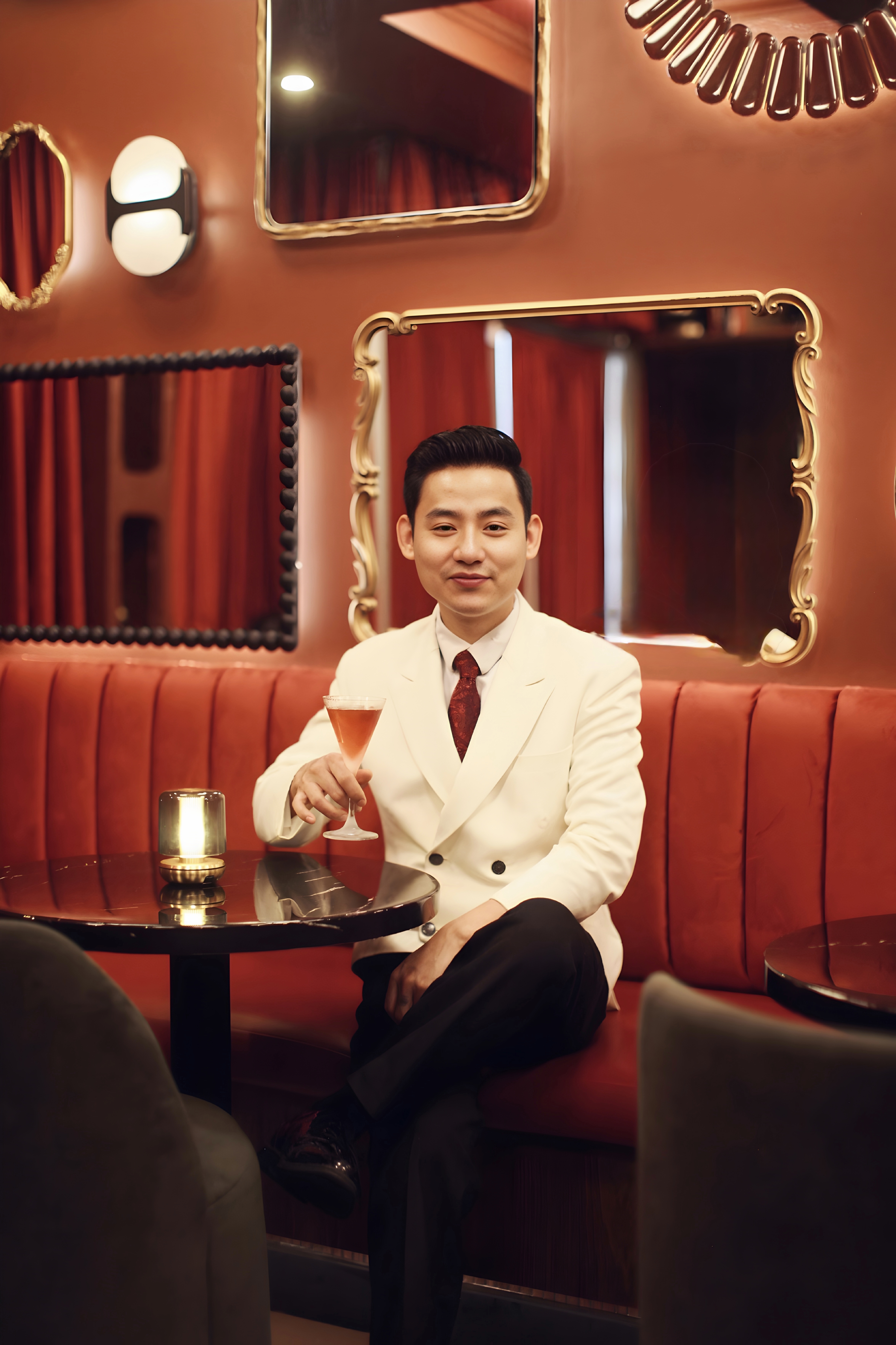 a man sitting at a table with a drink