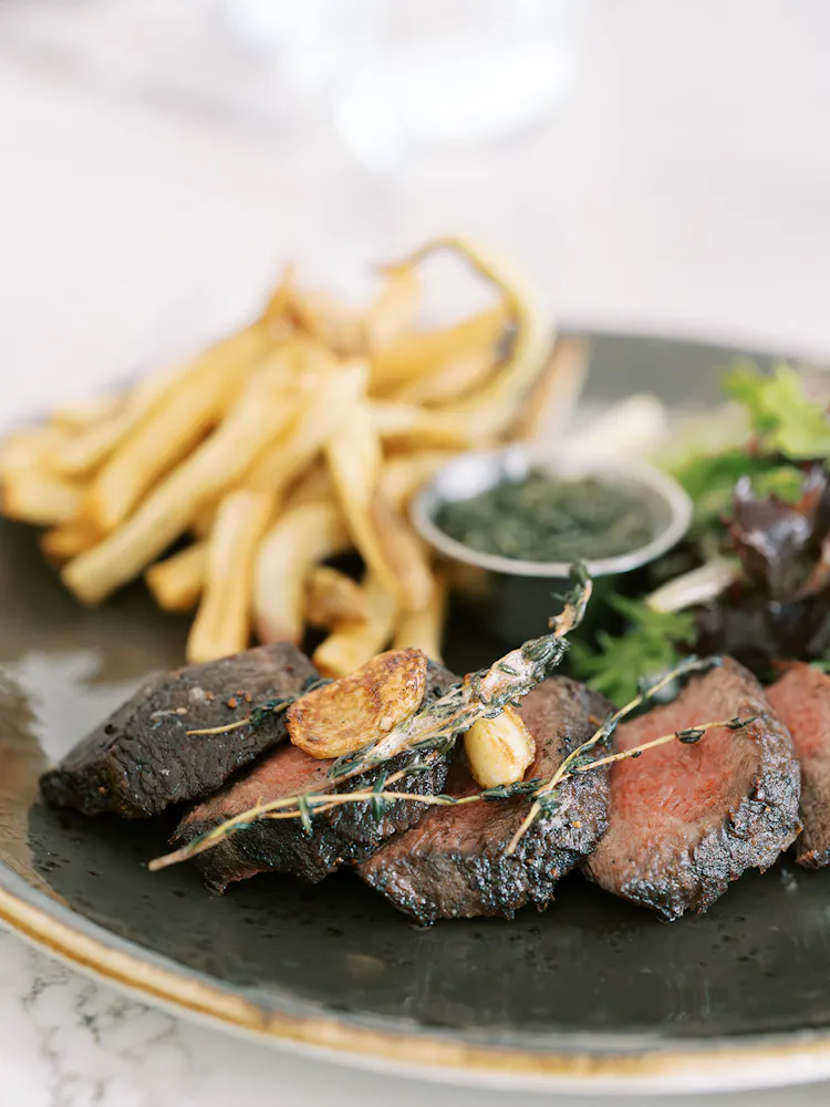 a plate of food with a side of french fries and a sauce