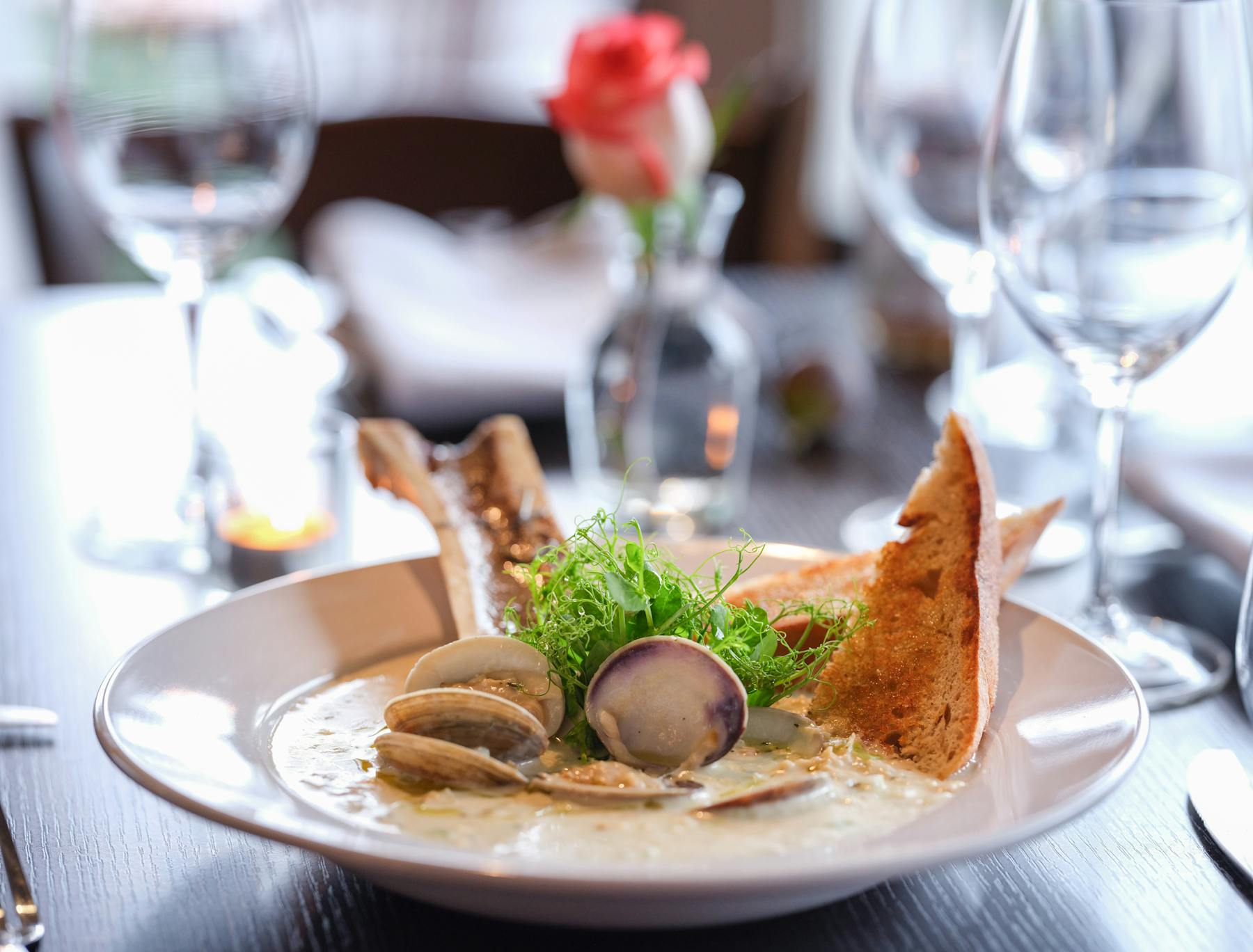 a plate of food and glasses of wine on a table