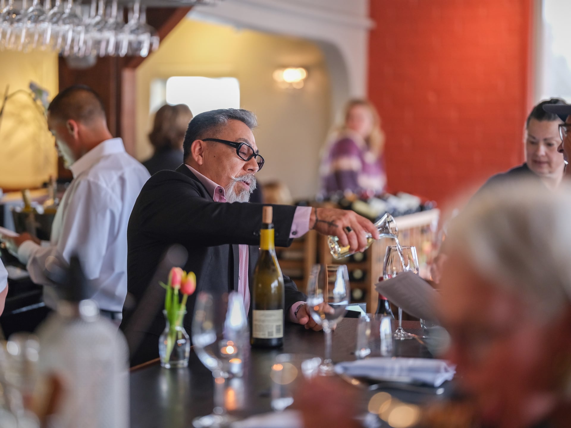 a group of people sitting at a table with wine glasses