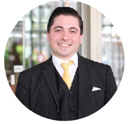 a man wearing a suit and tie smiling at the camera