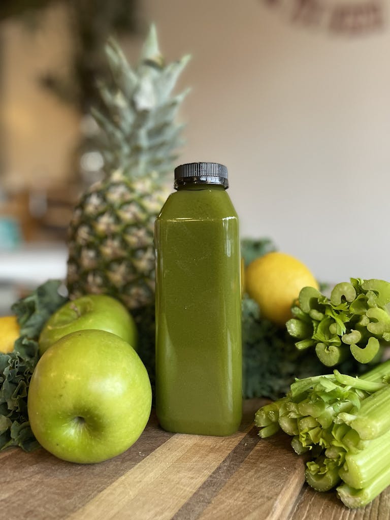 a green apple on top of a wooden cutting board