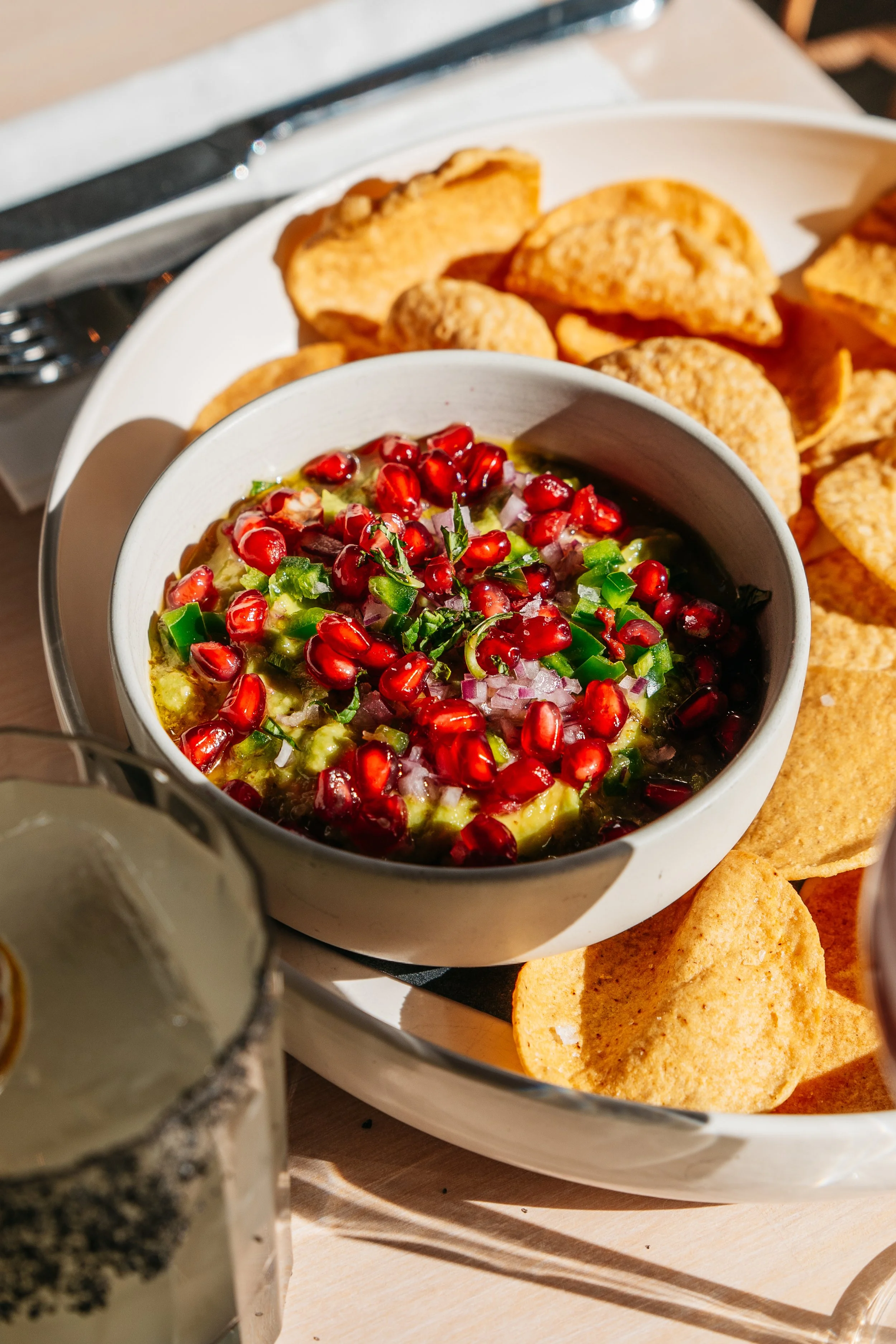 a bowl of fresh guacamole and a side of corn tortilla chips