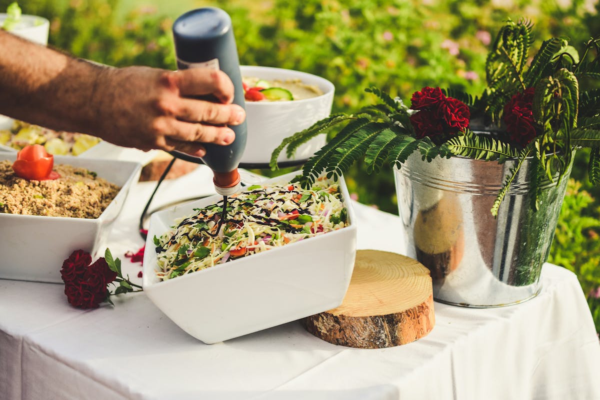 a person holding a plate of food on a table