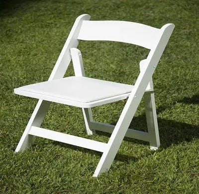 a couple of lawn chairs sitting on top of a grass covered field