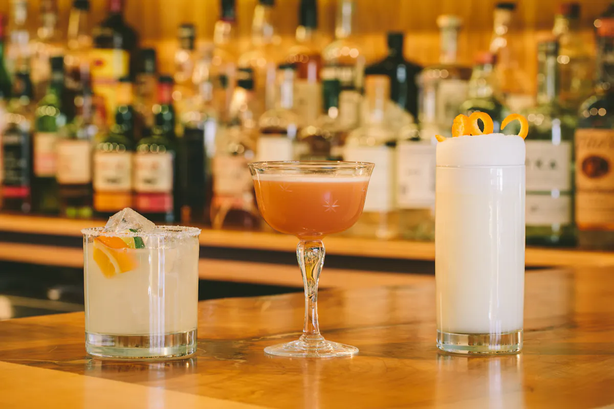 Three cocktails lined up at the bar