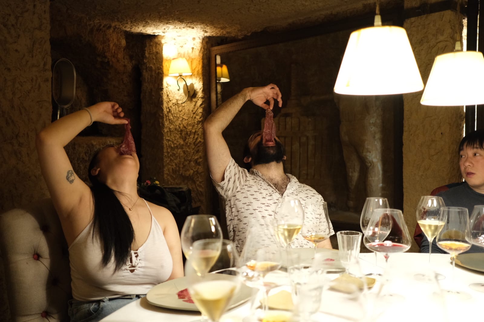 a woman sitting at a table with wine glasses