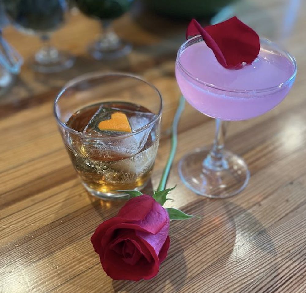 a glass of wine sitting on top of a wooden table