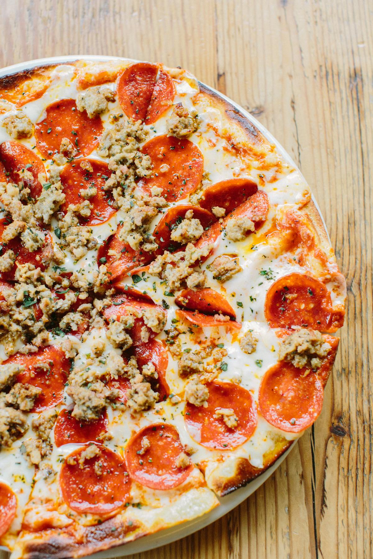 a pizza sitting on top of a wooden table